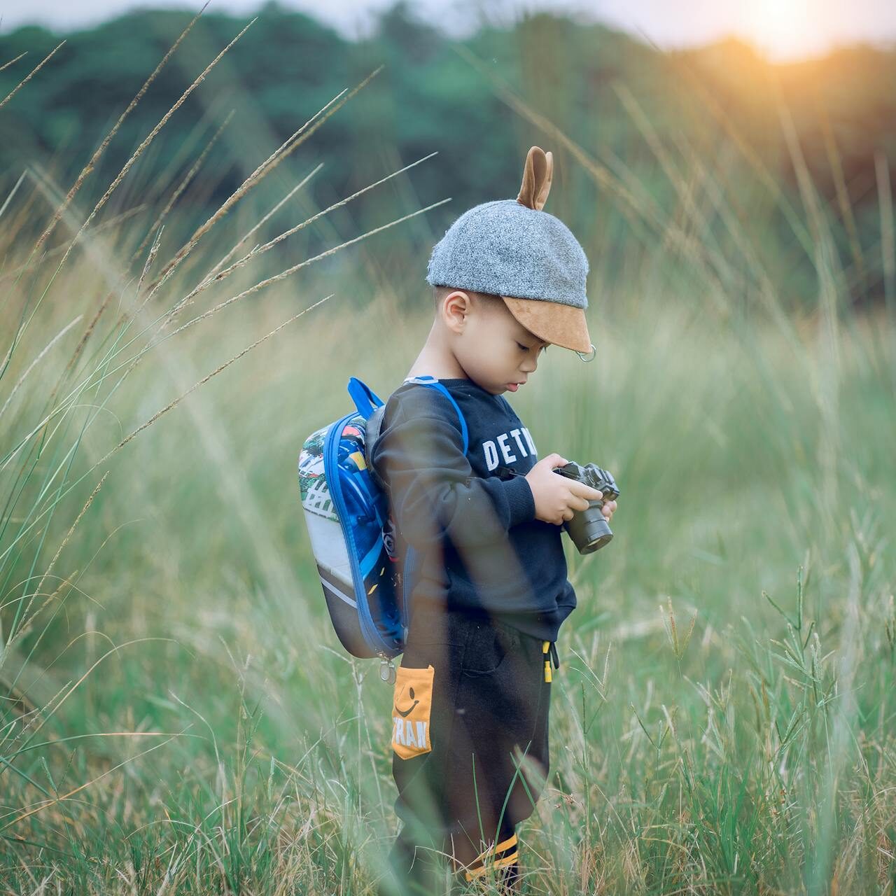 little boy taking pictures in field playing little boy taking pictures in field playing